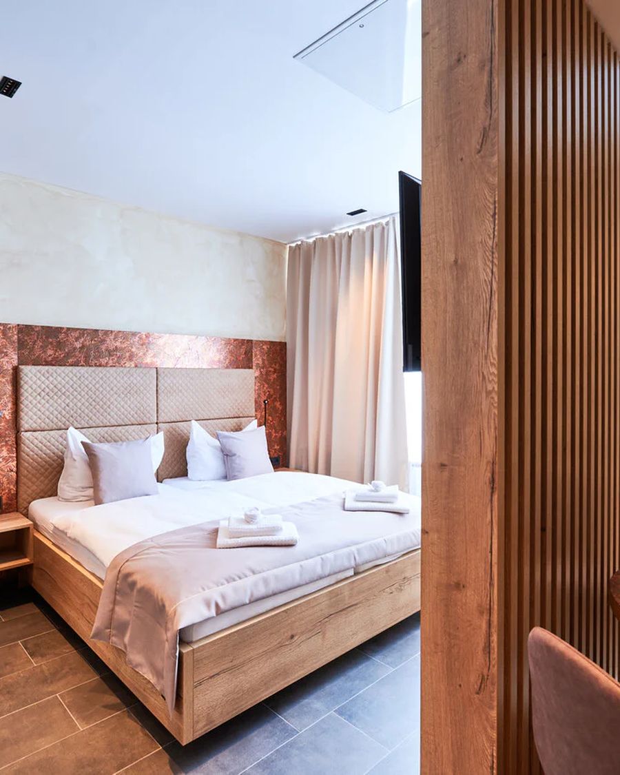 Suite im Hotel 53° Nord mit Doppelbett, Sitzecke und Holzlamellenwand