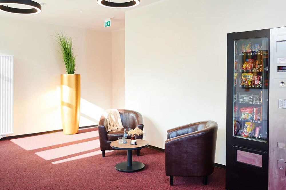 Aufenthaltsbereich mit Sesseln und Snackautomat
