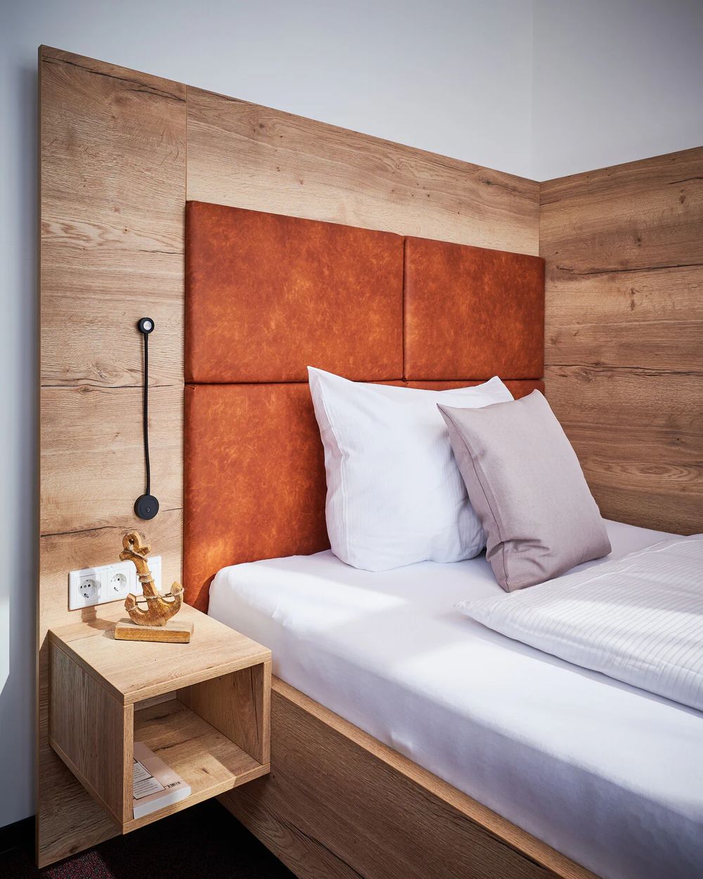 Bett im Einzelzimmer mit Kopfteil aus Leder