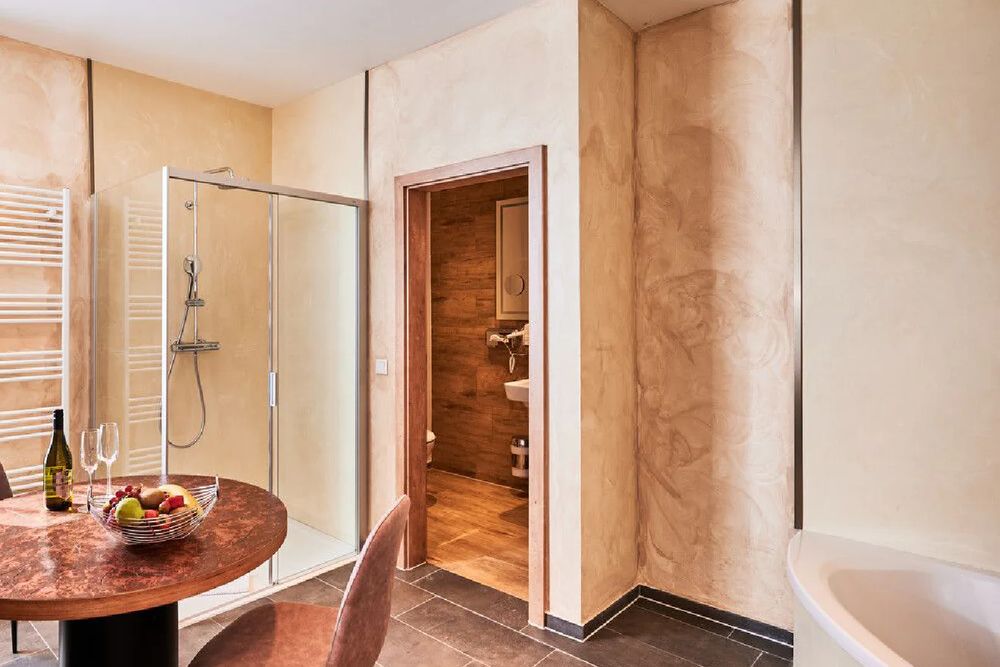 Bad der Suite mit Badewanne und Sitzecke im Hintergrund