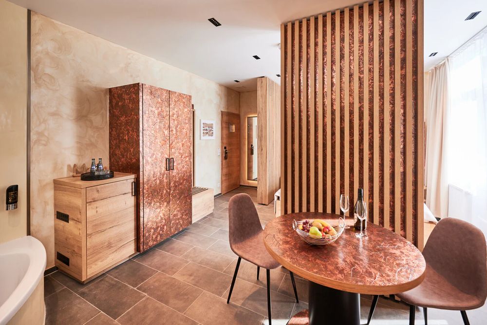 Wohnbereich der Suite mit Esstisch und Lamellenwand