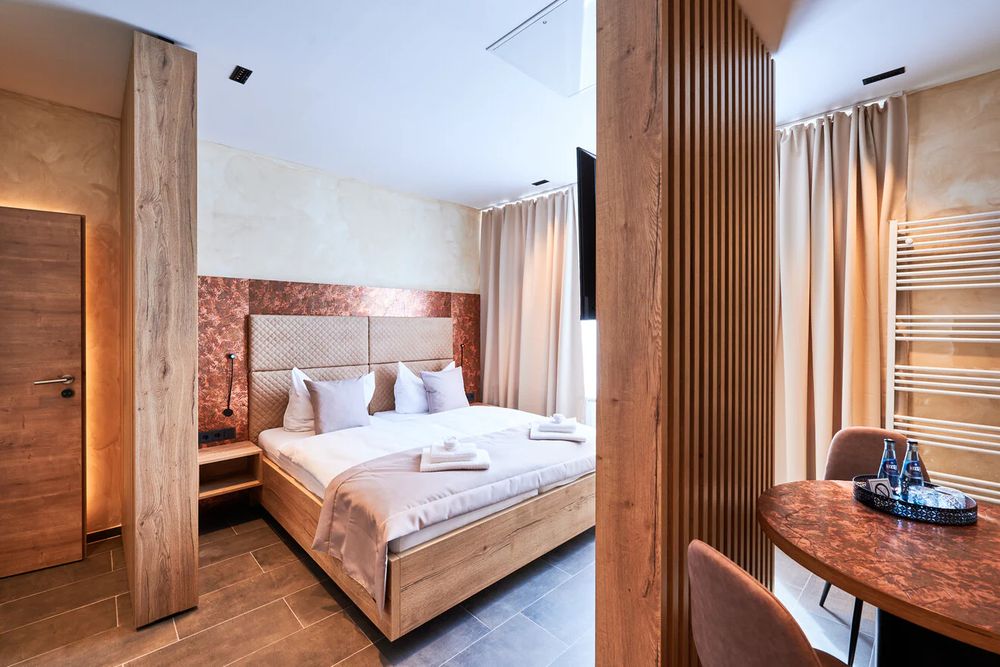 Suite im Hotel 53° Nord mit Doppelbett, Sitzecke und Holzlamellenwand